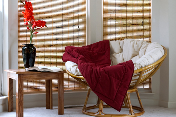 corner in living room with comfortable papasan chair, table and gladiolus flowers